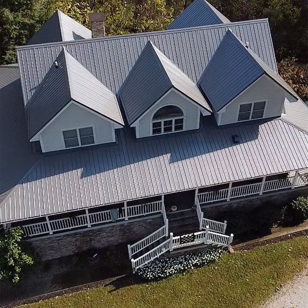 Light gray standing-seam metal roof on a porch-front home